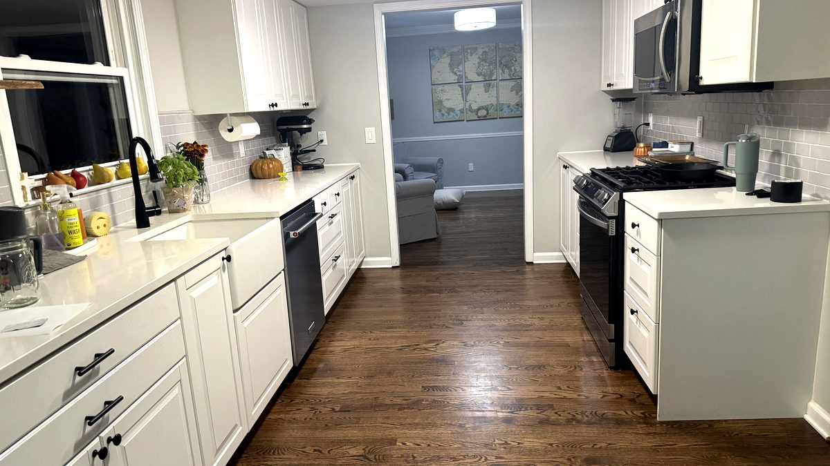 Kitchen view showing gas range, subway tile, and open layout